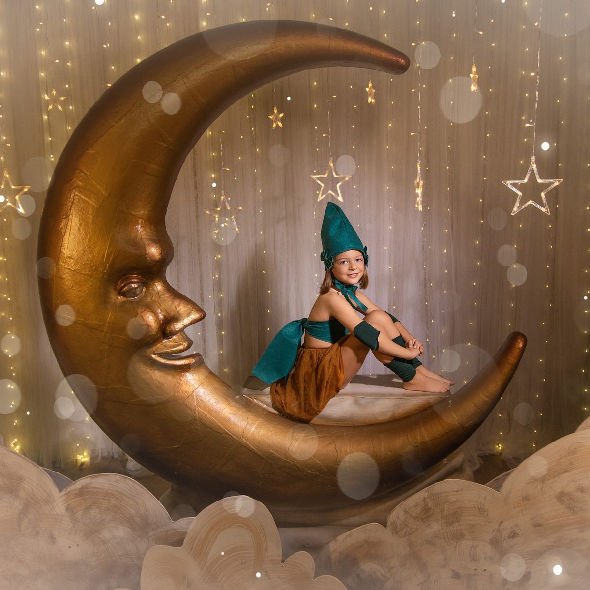Niña con gorro de duende sentada en la luna creciente del decorado de Navidad en Murcia