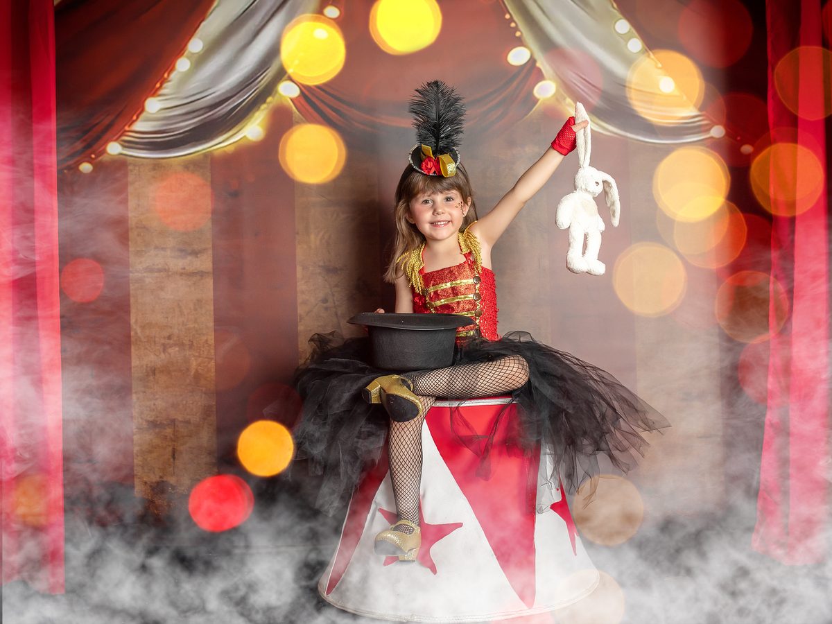 Niña con vestido rojo jugando con un aro dorado en las fotos de Navidad de Murcia