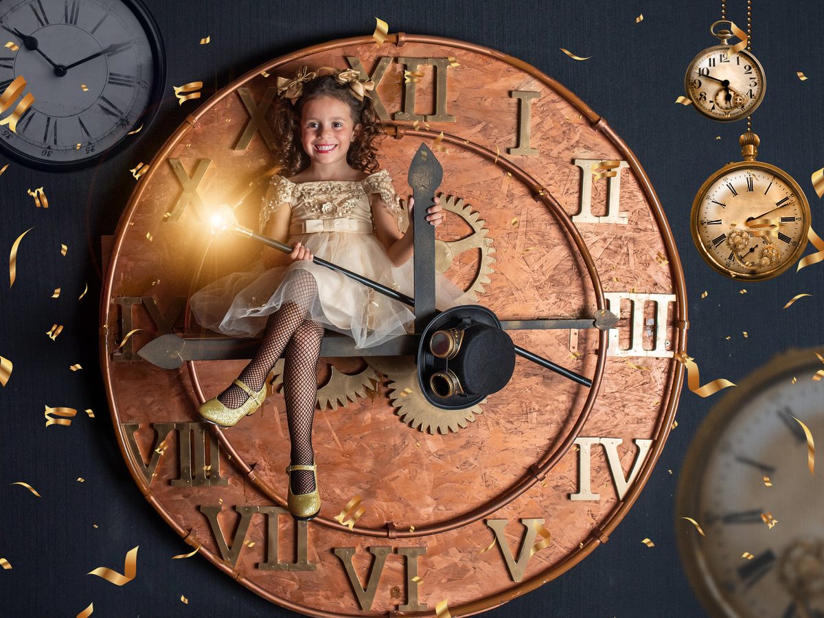 Niña con vestido dorado sobre el reloj gigante de las fotos de Navidad en Murcia
