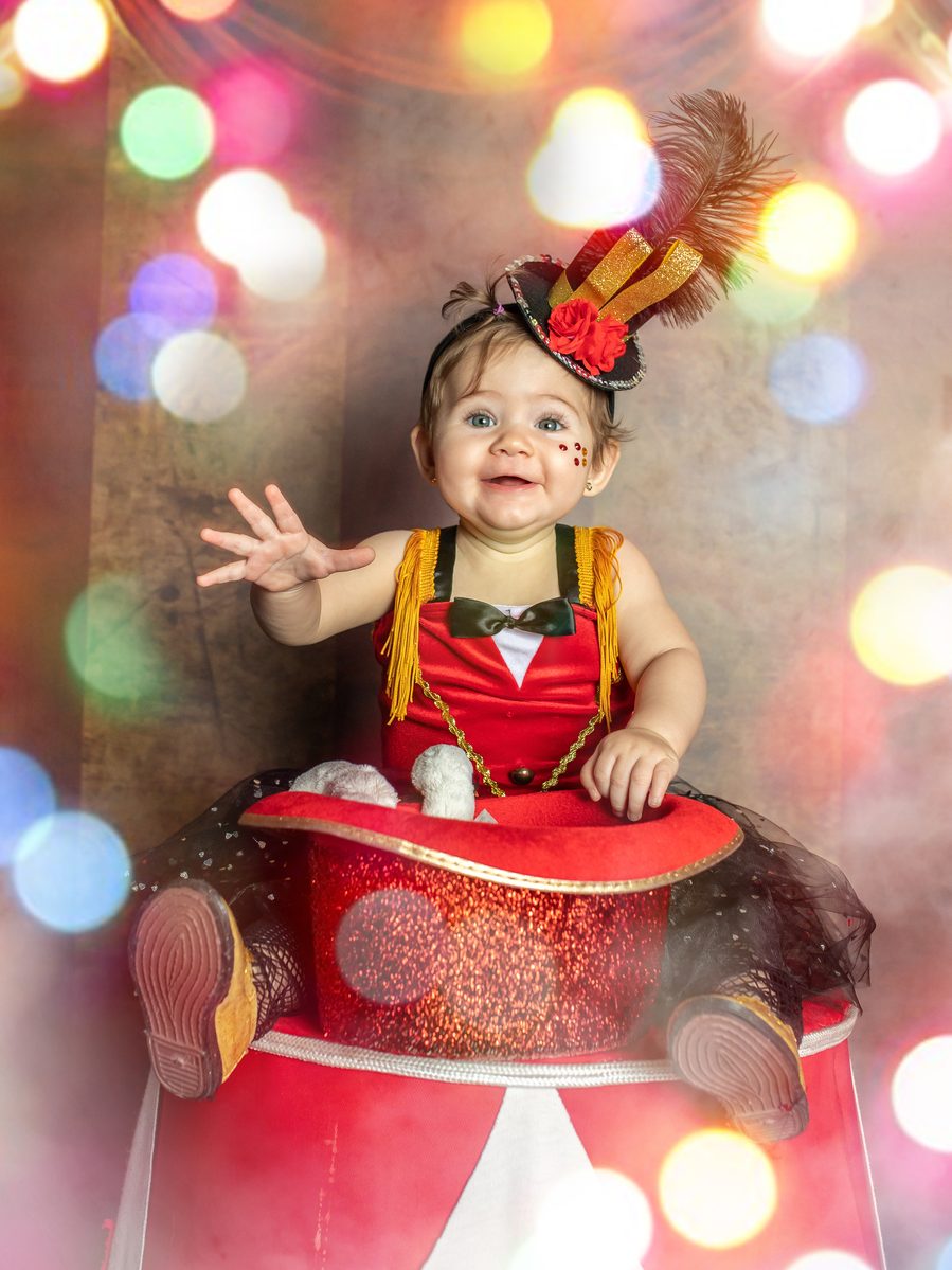Niña con vestido rojo bailando con un aro y luces doradas en Murcia