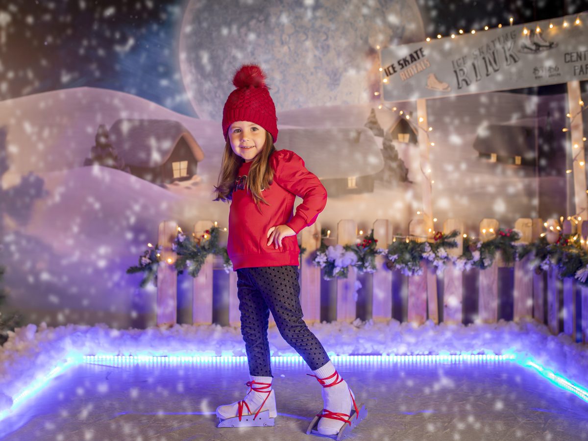 Niña con abrigo rojo en el decorado nevado de la campaña de Navidad de Murcia