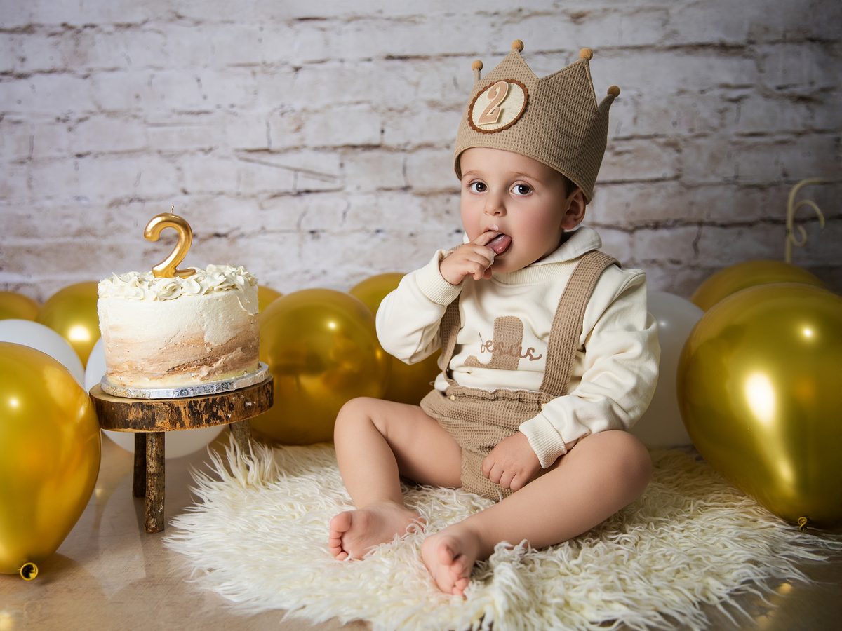 Niño con gorro de fiesta y tarta en la sesión smash cake en Murcia
