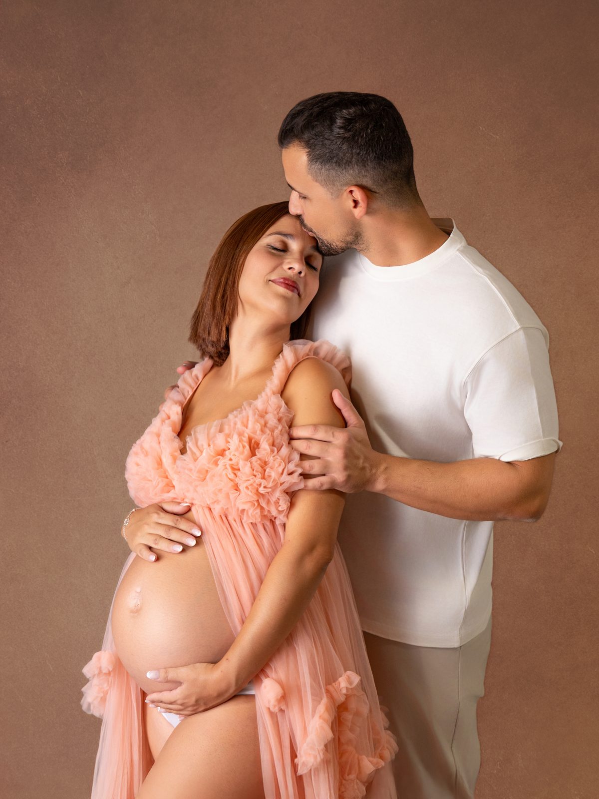 Pareja esperando un bebé con vestido rosa en una sesión de embarazo en Murcia