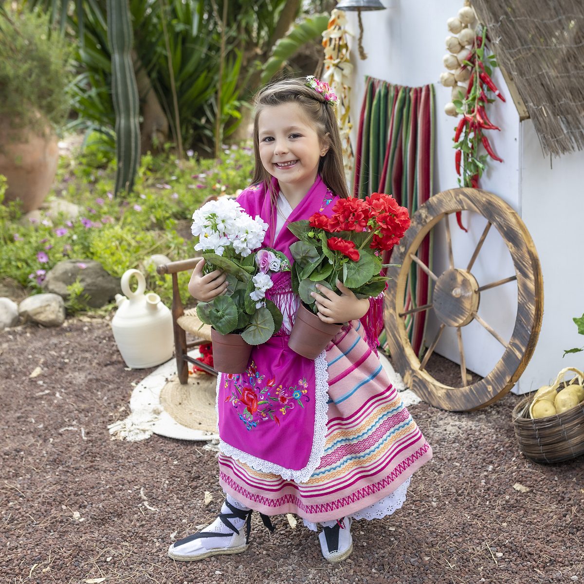 Niña con traje de huertana y ramo de flores en una sesión infantil en Murcia