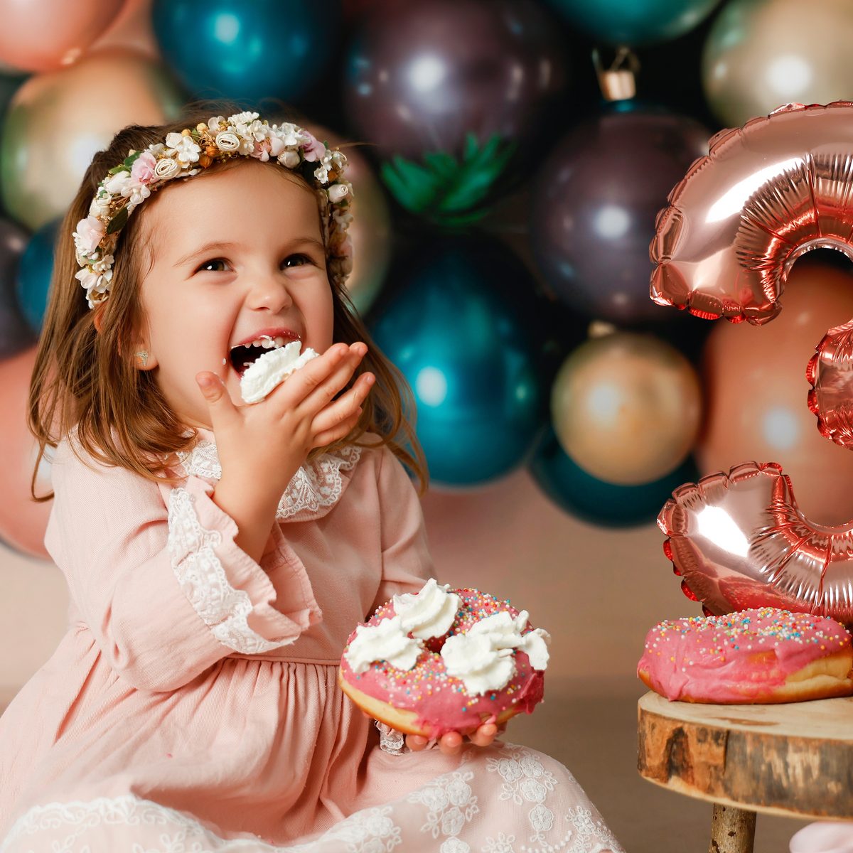 Niña con globos comiendo un donut en una sesión infantil en Murcia